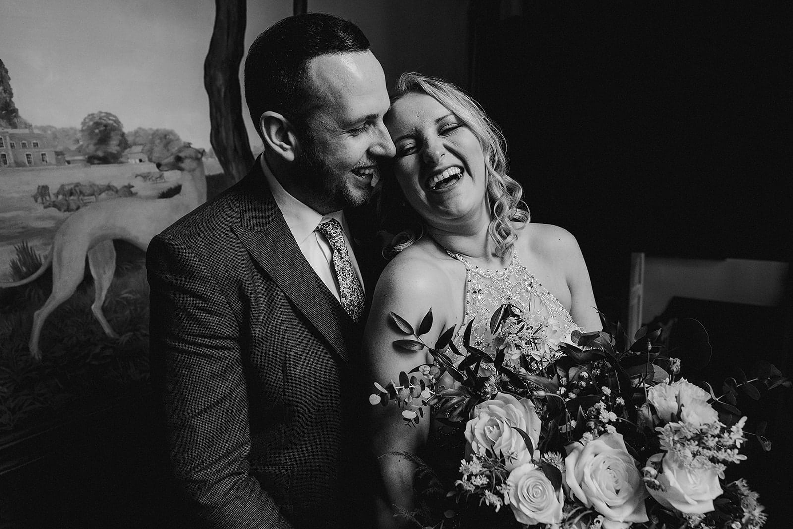 Black and white photo of bride and groom laughing at Iscoyd Park wedding taken by Shropshire wedding photographer, Indie Love Photography