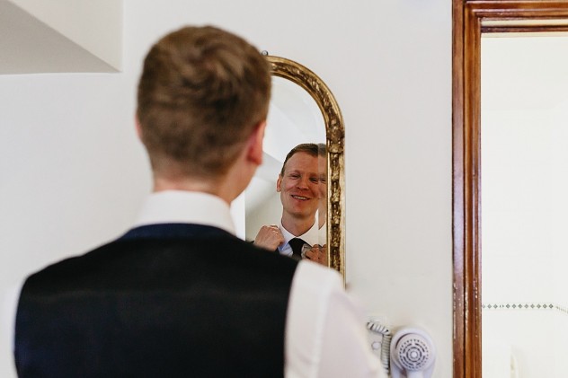 Groom looking in mirror