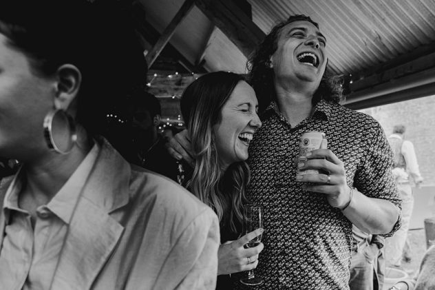 Black and white image of man and woman laughing during Wilde Lodge wedding reception