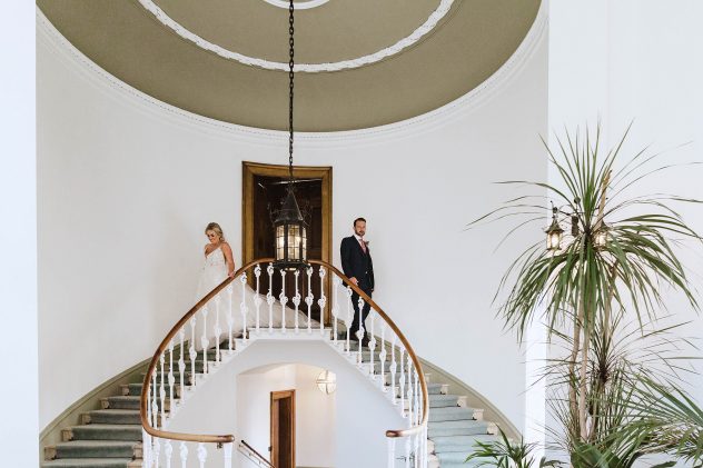 Bride and groom walking down staircase in Shropshire Wedding Venue