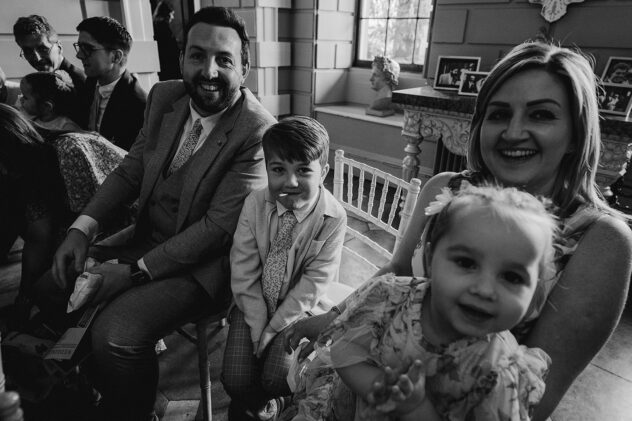 Black and white candid image of family of four, wedding guests at Davenport House