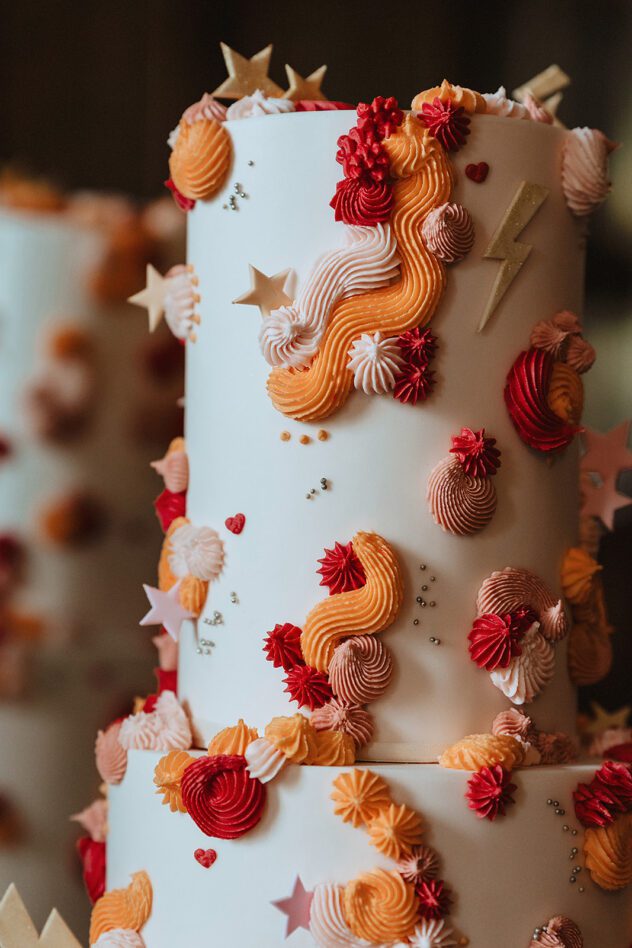 Bowie inspired wedding cake with red and orange icing, lightning bolts and stars