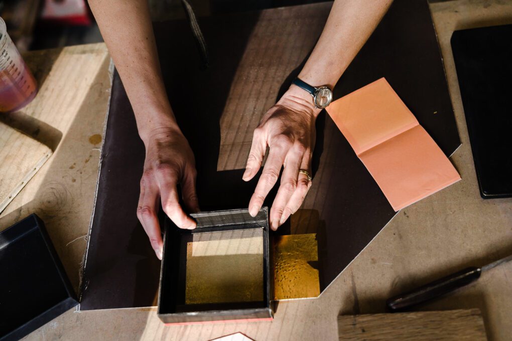 Hands creating gold leaf gilding for brand storytelling