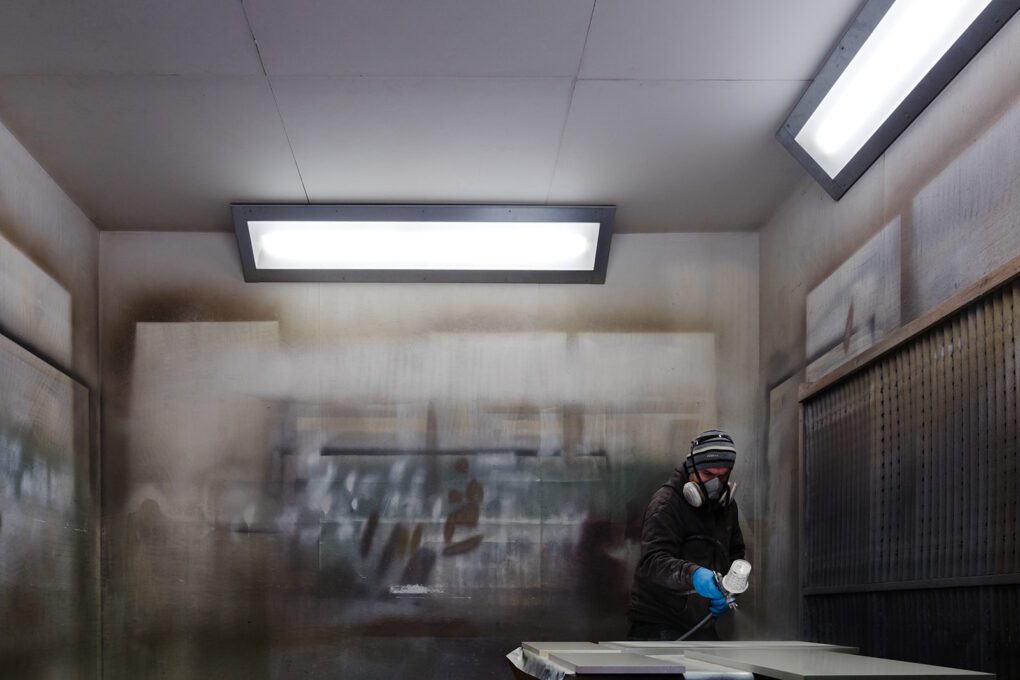 Man wearing PPE in paint spray booth. Brand storytelling