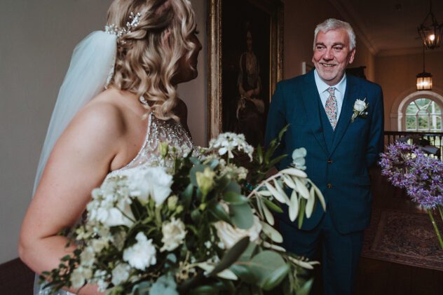 Father of the bride smiles at his daughter whilst waiting for wedding ceremony at Iscoyd Park
