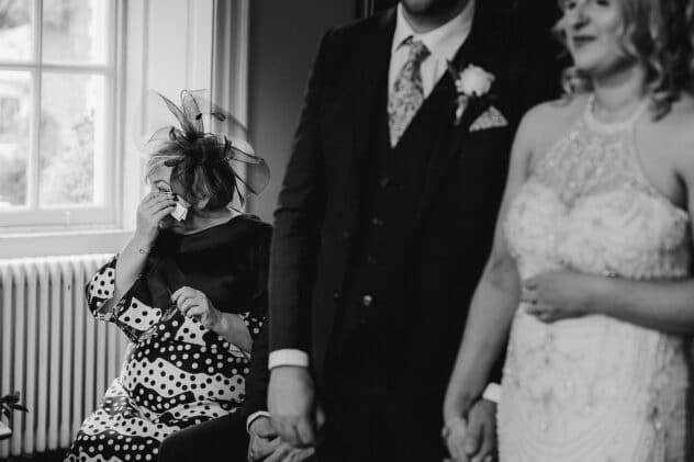 Mother of the Groom wipes away a tear during ceremony at Iscoyd Park