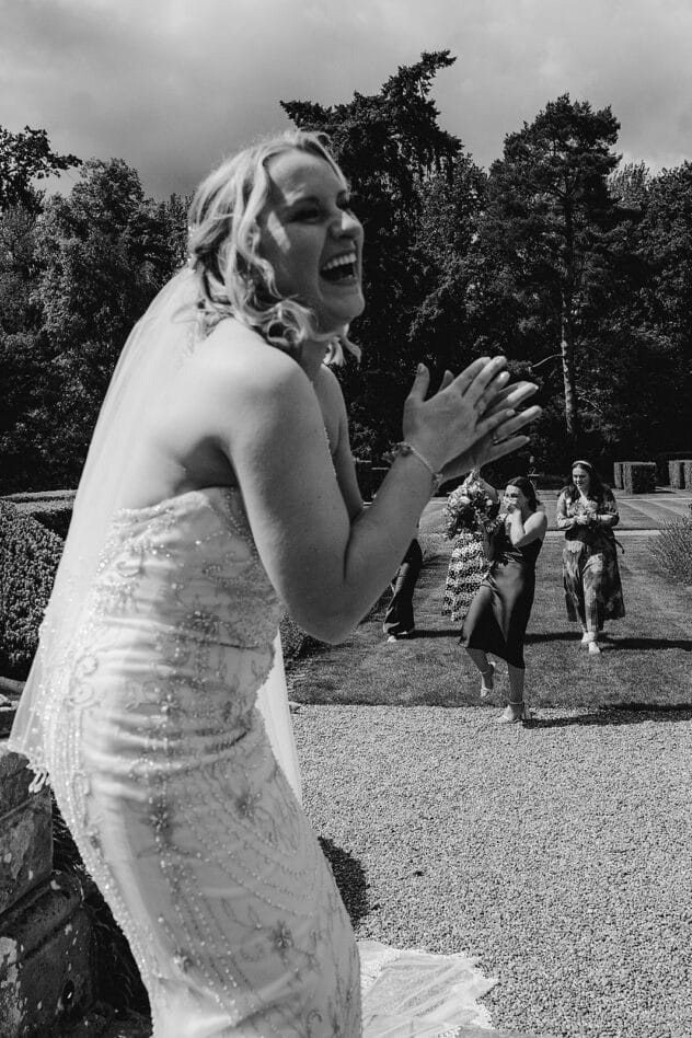 Indie laughs and claps as guest catches bouquet at Iscoyd Park Wedding