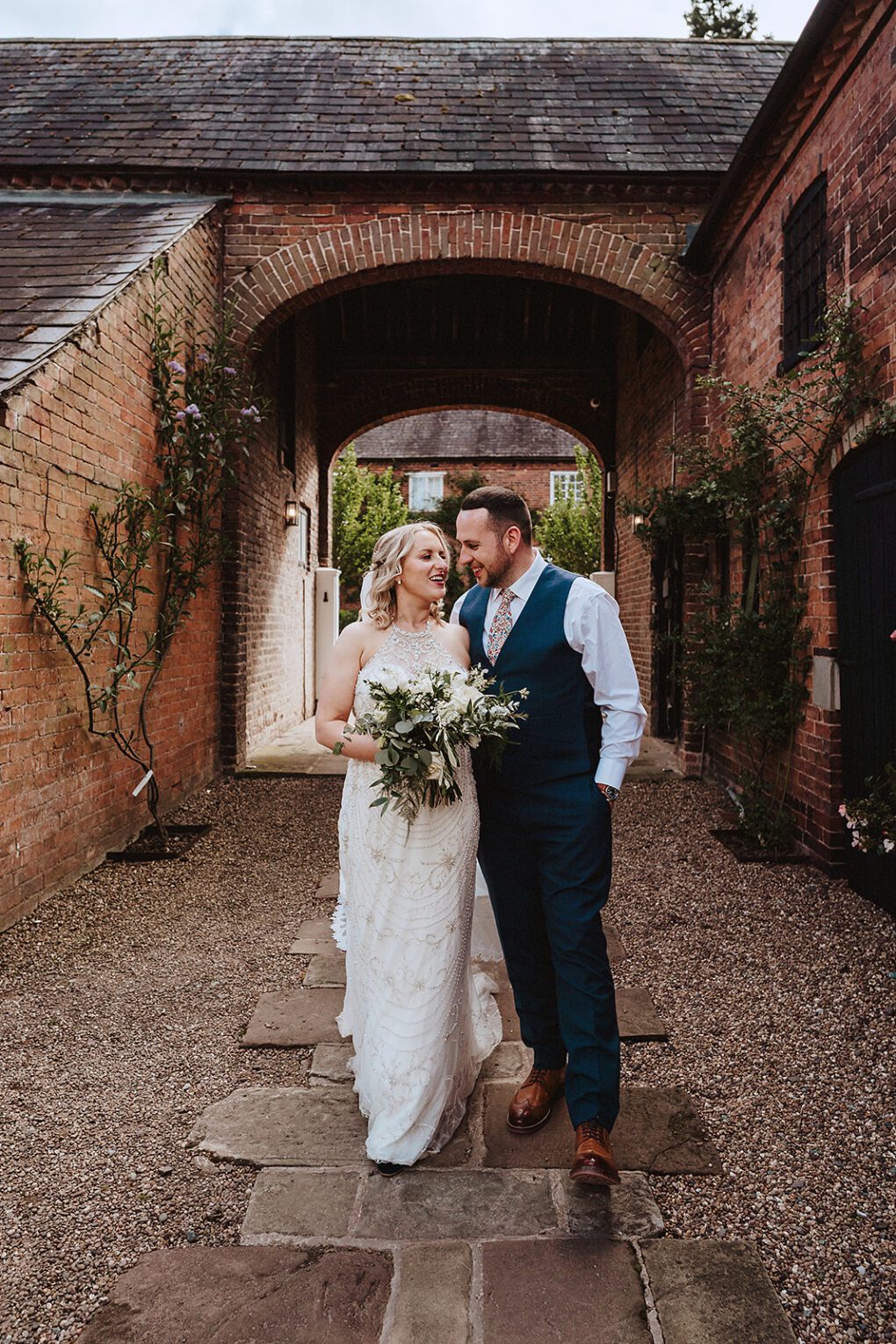 Bride and groom walking through the ground of Iscoyd Park
