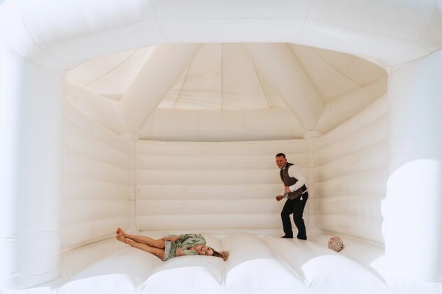Guest lying on white wedding bouncy castle
