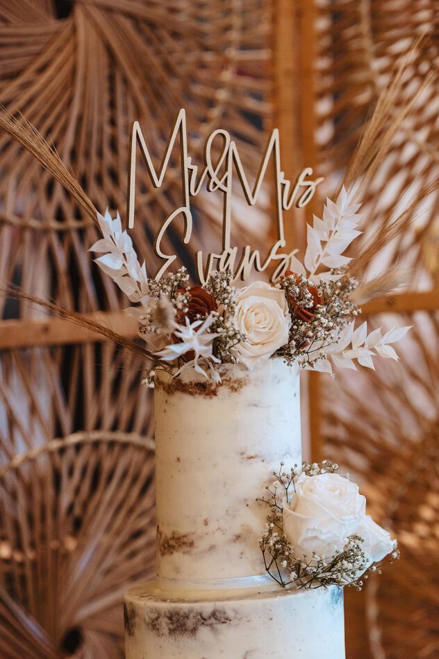 A naked wedding cake with Mr and Mrs Evans wooden sign on top at Stanford Farm Wedding