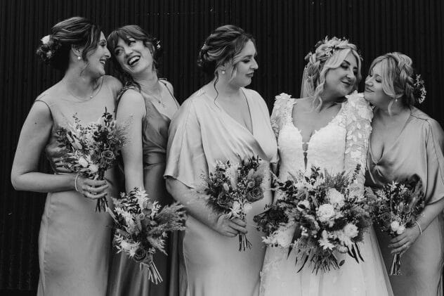 Bride with bridesmaids, they smile at each other
