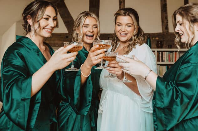 Bride and bridesmaids laugh and cheers at Pimhill barn wedding