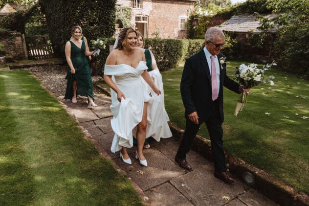 Bride and bridesmaids walking to ceremony at Pimhill barn wedding