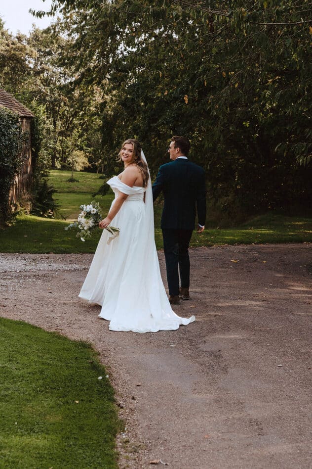 Bride and groom stroll through the grounds of Pimhill barn