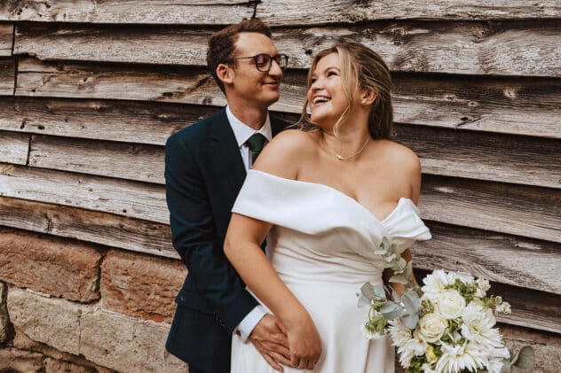 Bride and groom against the barn wall at Pimhill barn wedding