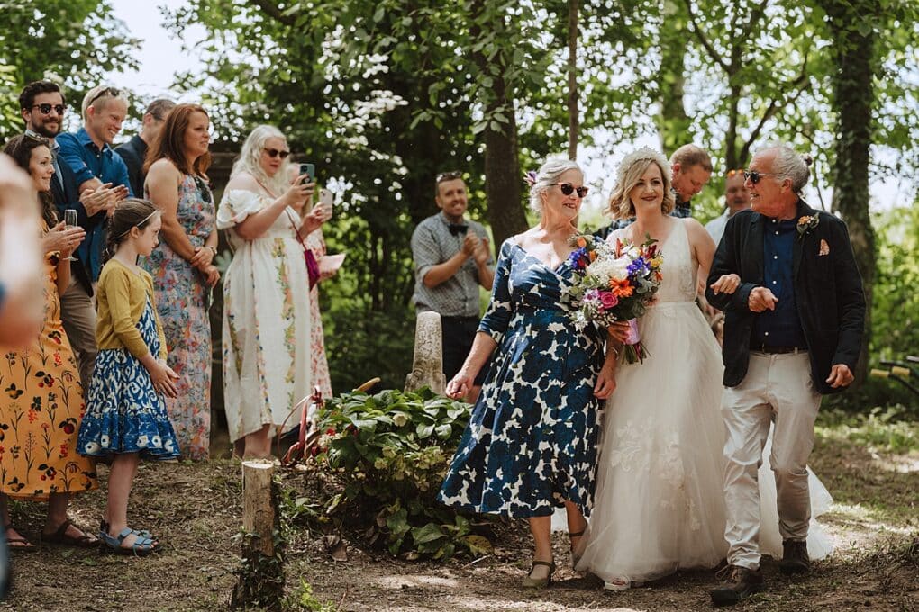Bride walking into ceremony with Mum and Dad