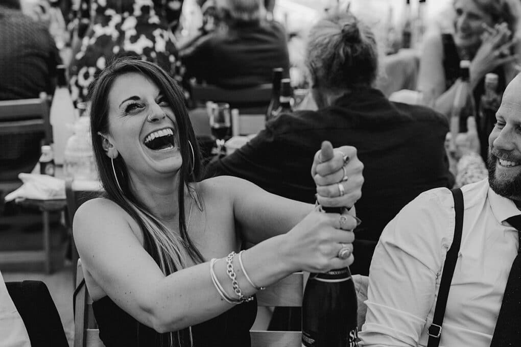 Candid Shropshire wedding photography of guest popping champagne cork