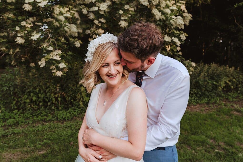 Wedding portrait of bride smilng and groom nuzzling