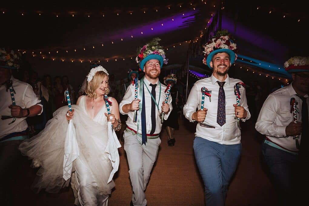 Candid Shropshire wedding photography of bride and groom morris dancing