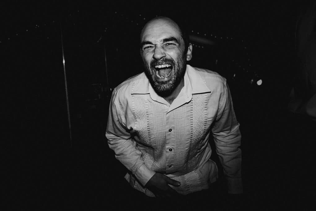 Candid Shropshire wedding photography of wedding guest singing on dancefloor