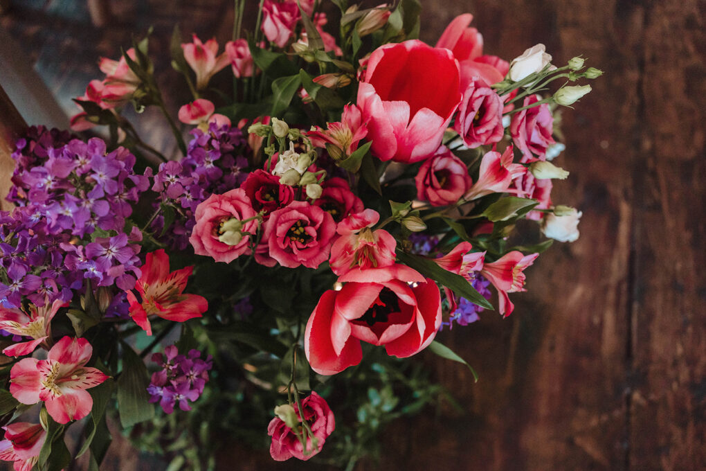 Hot pink tulips in a vase at a spring industrial wedding
