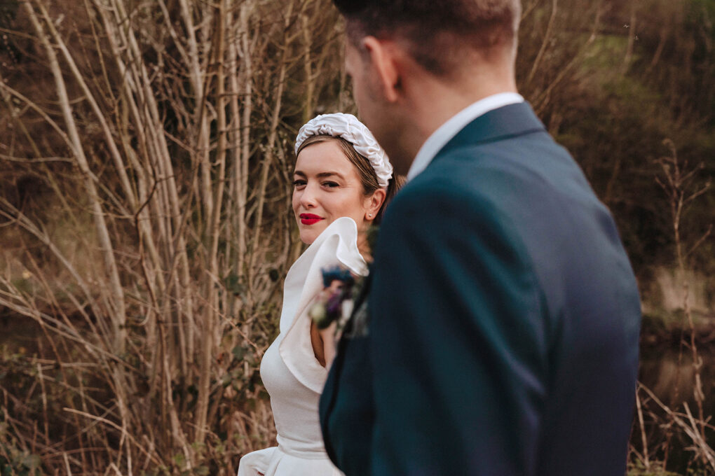 Non-traditional couple walking through an industrial warehouse during a spring wedding in Halfax